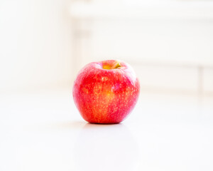 Solitary red apple in white kitchen