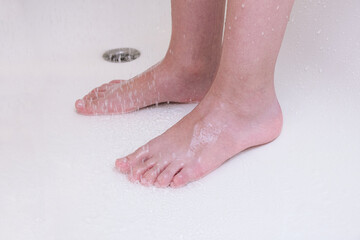 Feet of a child taking shower, a kid washing legs in a bathroom, hygiene and cleansing routine