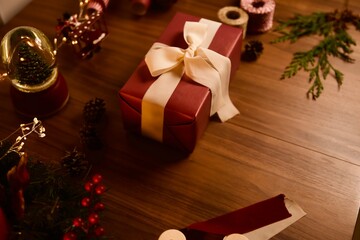 Christmas present with white bow-knot and holiday lights on background. Precedent decoration concept..