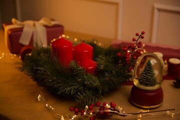 Christmas composition with Christmas gift, snowball, candle, wrapping paper and holiday lights. Wrapping presents on Christmas. Holidays gifts.