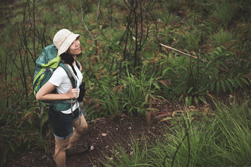 Woman hiking at sunset mountains with heavy backpack Travel Lifestyle wanderlust adventure concept summer vacations outdoor alone into the wild