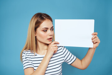 Naklejka premium Woman holding sheet of paper striped T-shirt Copy Space cropped view blue background