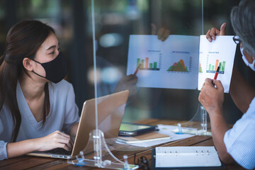 Young female student and freelancer presenting and working at the outdoor cafe with face mask using computer laptop