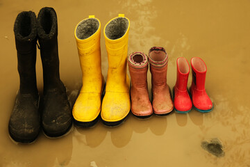 Family dirty wellingtons in dirty water black, yellow, pink, red.