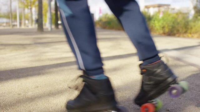 Close shot of male in roller skates going around in circles, in slow motion 