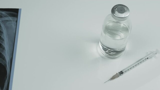 X-ray of human lungs, jar with vaccine and medical syringe, vaccination medication on a white background