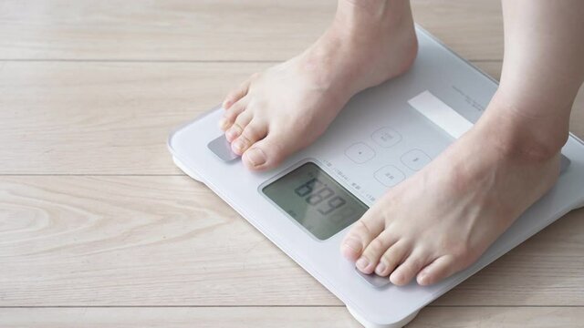 体重計に乗る女性　パン