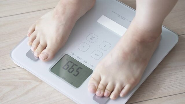 体重計に乗る女性　パン