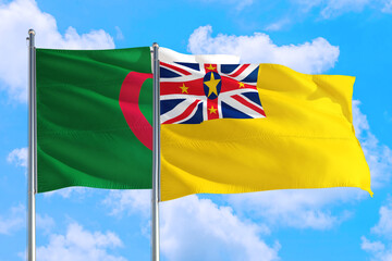 Niue and Algeria national flag waving in the windy deep blue sky. Diplomacy and international...