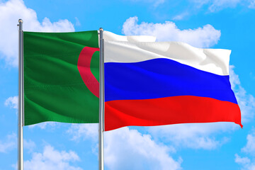 Russia and Algeria national flag waving in the windy deep blue sky. Diplomacy and international relations concept.