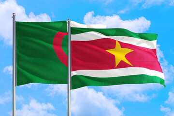 Suriname and Algeria national flag waving in the windy deep blue sky. Diplomacy and international...