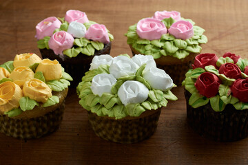 Fototapeta na wymiar cupcakes decorated with rose design chantilly, placed on a wooden base