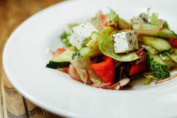 Greek salad on wooden background top view. Space for text. Healthy food