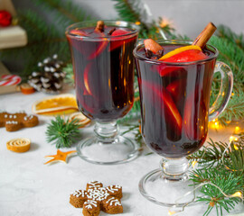 Close-up of Сhristmas hot mulled wine with carnation, cinnamon, cardamom and anise on wooden background with Christmas decorations New Year drinks.