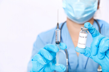 A vial with a vaccine for the prevention of a virus in the hands of a doctor and a syringe.