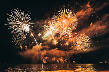Fototapeta premium beautiful colored fireworks over the water. Fireworks Festival.