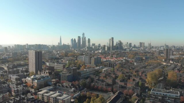 dolly back drone shot from residential London looking towards the financial center of the capital