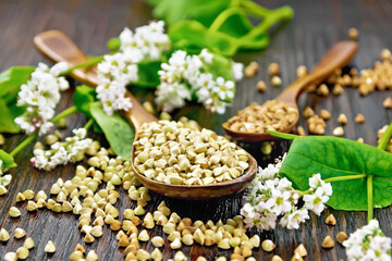 Buckwheat green and brown in spoons on wooden board