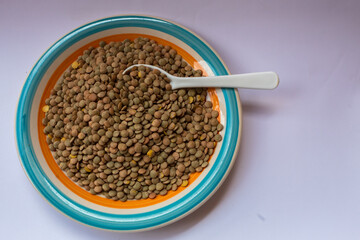 Some brown lentils  and a spoon.
