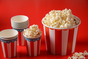 Buckets with delicious popcorn on red background 