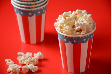 Buckets with delicious popcorn on red background 