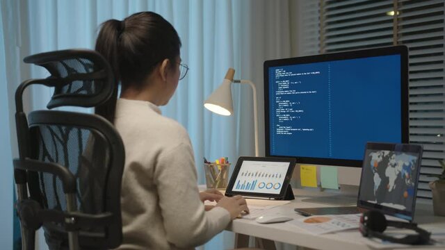 Back rear view of young asian woman, freelance data scientist work remotely at home coding programing on Big data mining, AI data engineering, IT Technician Works on Artificial Intelligence Project.