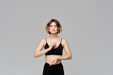 woman gesturing with her hands slim figure meditation sport gray background