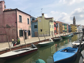 Burano island canal and colorful houses with boats in Venice Italy