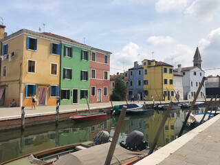 Burano island canal and colorful houses with boats in Venice Italy