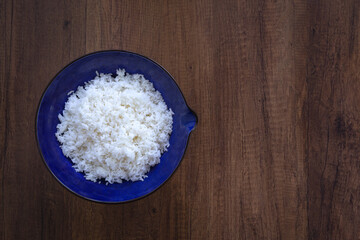 Cooked jasmine rice in bowl with napkin on wooden table. Thai Jasmine rice.