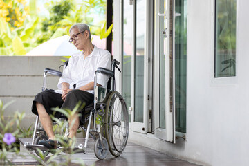 Obraz premium Old elderly patient with disabilities,sit alone in a wheelchair at home,movement disorder,feel lonely,Asian senior people suffering from Alzheimer's disease,dementia,physical or mental health problems