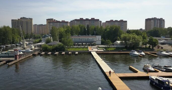 4K high quality calm windless bright summer morning aerial video of Moscow Channel yacht club embankment, green trees, wooden pier and shore with moored anchored boats and yachts near Moscow, Russia
