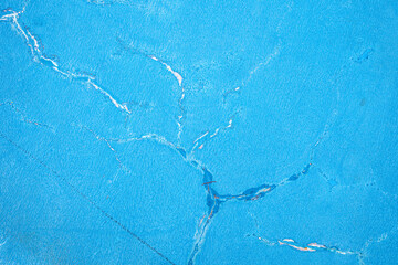 blue paint on the wall. close up of painted blue weathered concrete wall with cracks.