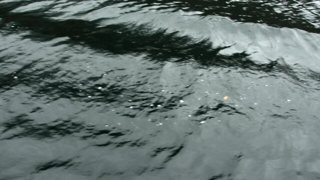 Close shot of the water of a lake from a boat.