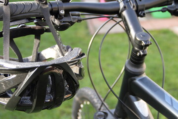 a bicycle helmet hangs on the handlebars of a mountain bike
