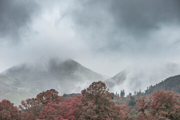 Stunning landscape image of Derwentwater in English Lake District during late Summer with still water and misty mountains in the distance