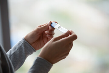 Two bars. Close up of woman hands holding positive home pregnancy test, confused female meeting...