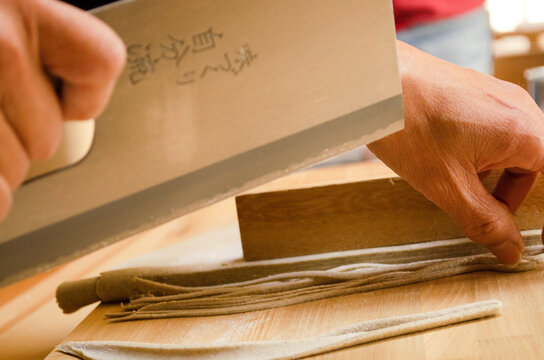 closeup of woman cutting soba noodles