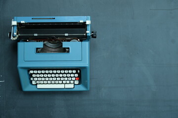 Fototapeta na wymiar macchina da scrivere su lasstra di ardesia con gessetti e scritte (amore, amici, mare) e spazio per scrittura