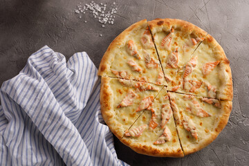 Appetizing pizza with salmon on a textured background. Delicious food concept. Close-up.