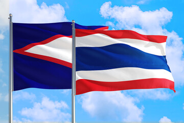 Fototapeta premium Thailand and American Samoa national flag waving in the windy deep blue sky. Diplomacy and international relations concept.
