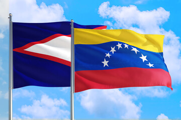 Venezuela and American Samoa national flag waving in the windy deep blue sky. Diplomacy and international relations concept.