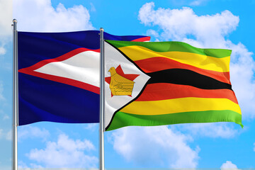 Zimbabwe and American Samoa national flag waving in the windy deep blue sky. Diplomacy and international relations concept.