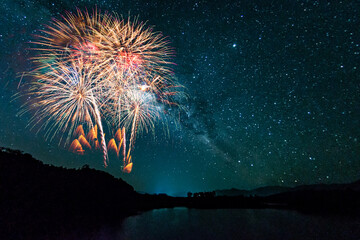 Colorful of fireworks display on milkyway in night sky background.