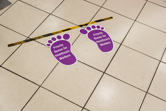 Dirty And Used Purple Floor Sticker Indicating Priority Queue For Healthcare Workers