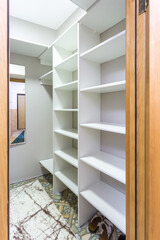 Fototapeta premium rows of shelves and clothes hangers in the wardrobe