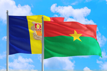 Burkina Faso and Andorra national flag waving in the windy deep blue sky. Diplomacy and international relations concept.