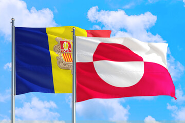 Greenland and Andorra national flag waving in the windy deep blue sky. Diplomacy and international relations concept.