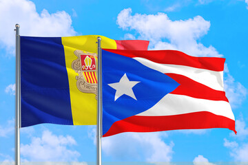 Puerto Rico and Andorra national flag waving in the windy deep blue sky. Diplomacy and international relations concept.