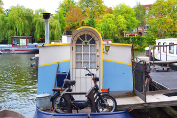 Houseboat in Amsterdam. Parked scooter in a foreground.